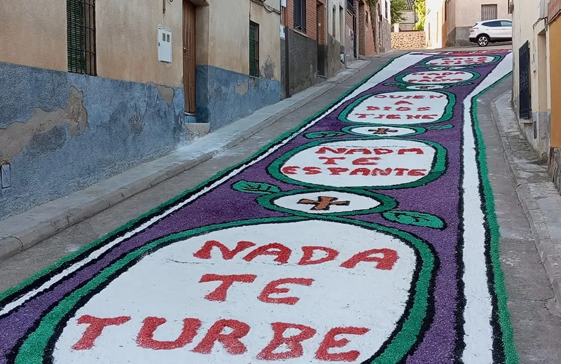 Calle decorada con alfombra que dice “Nada te turbe” en el Corpus Christi de Los Navalmorales