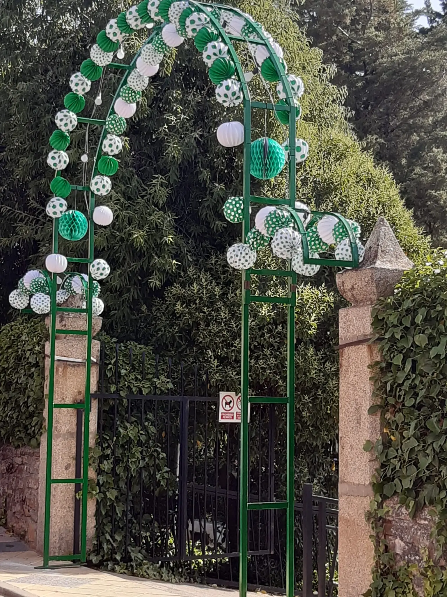 Arco de entrada decorado con farolillos verdes y blancos
