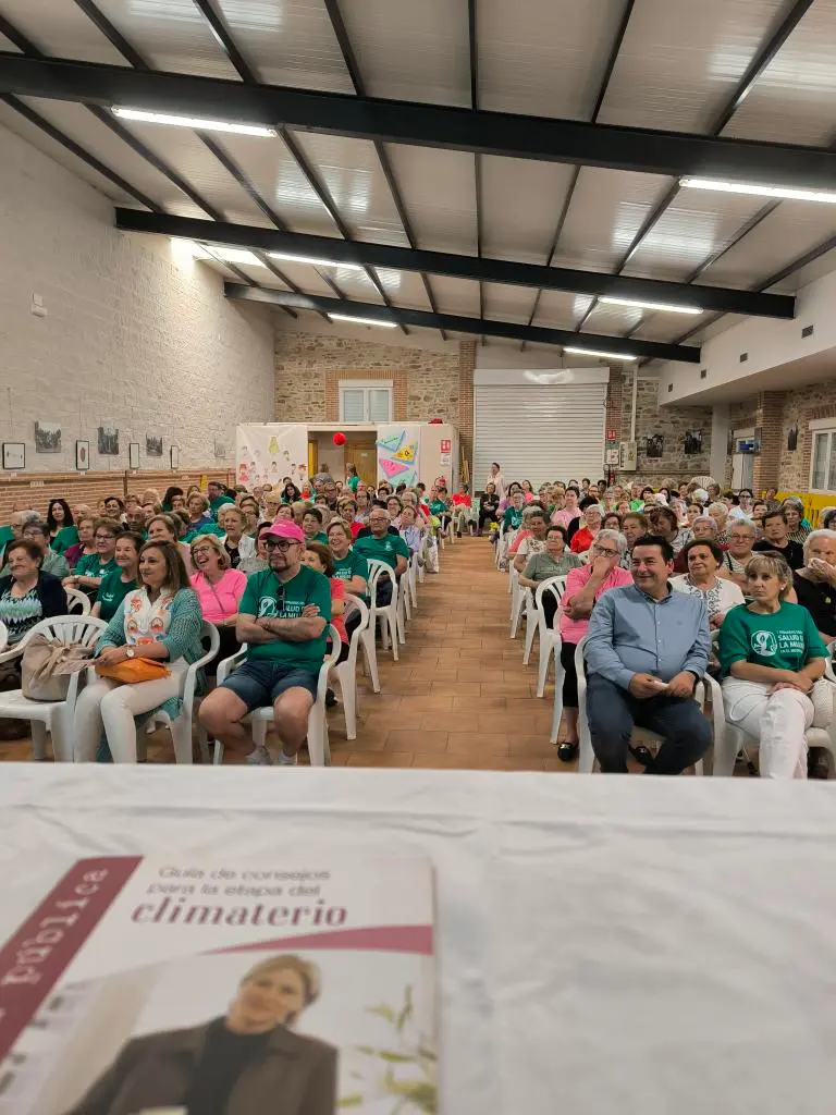 Vista frontal de la audiencia durante una ponencia sobre bienestar femenino.