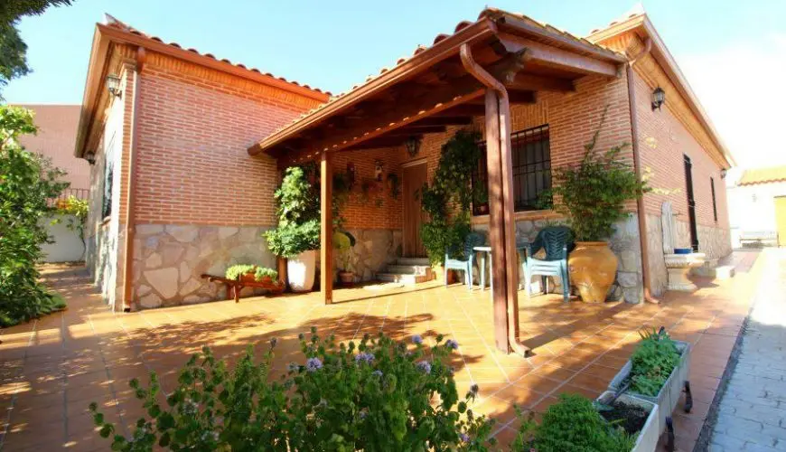 Fachada de la casa rural La Chocolatera en el barrio de Las Cruces, rodeada de vegetación