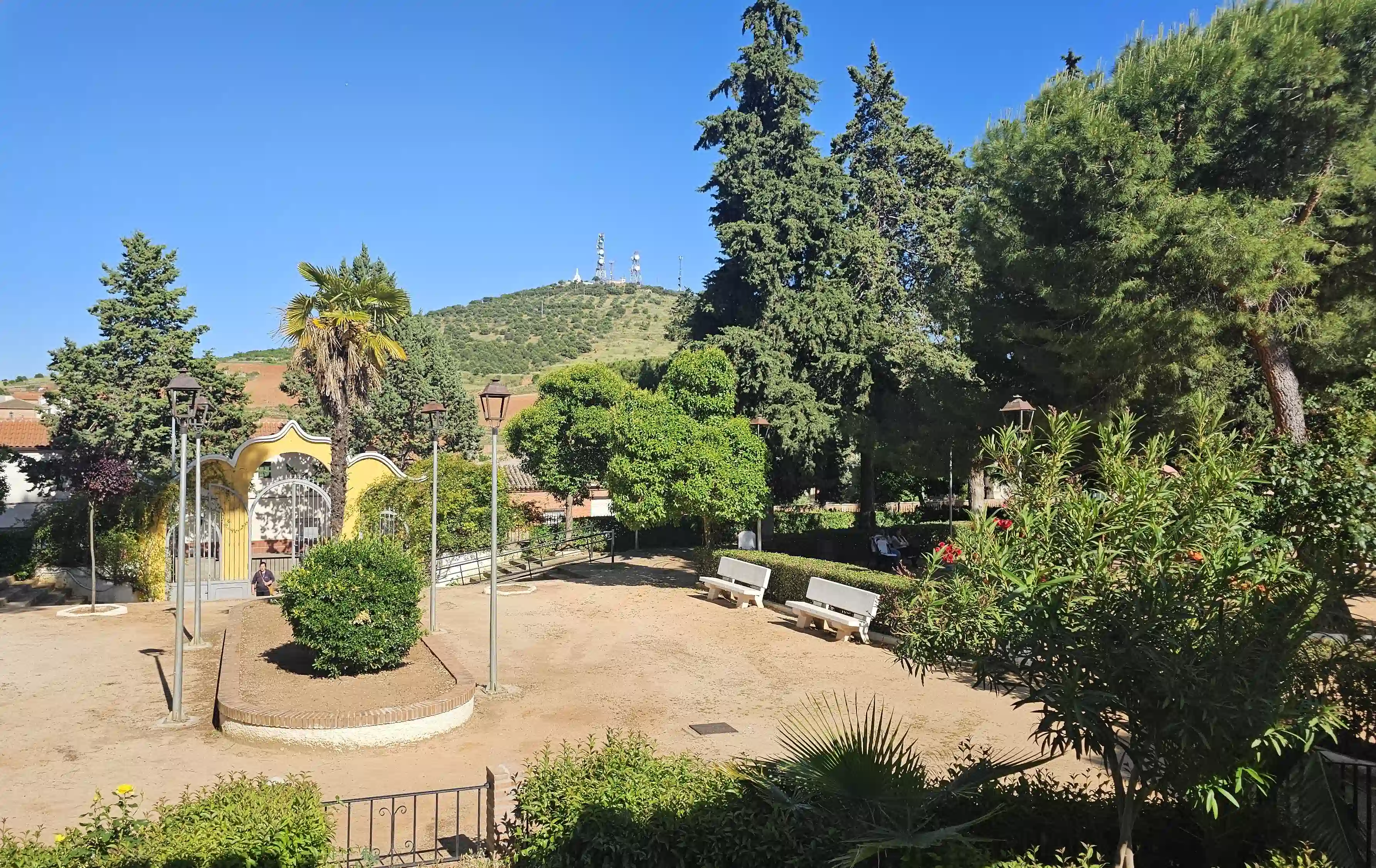 Entrada al parque de Los Navalmorales con bancos y árboles frondosos